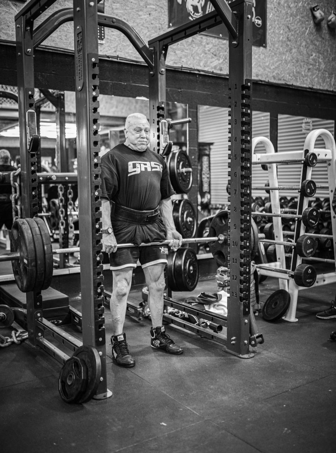 A member set up for a deadlift inside a power rack