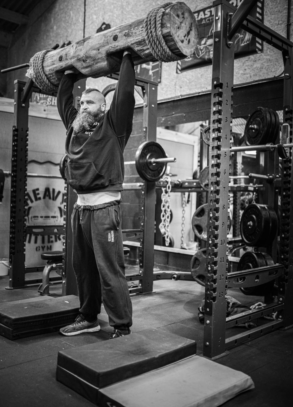 A member pressing a log overhead in the gym